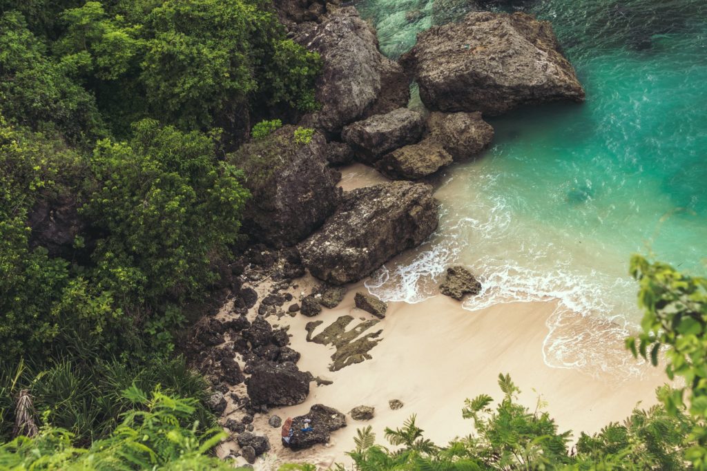 aerial view of seashore near large grey rocks